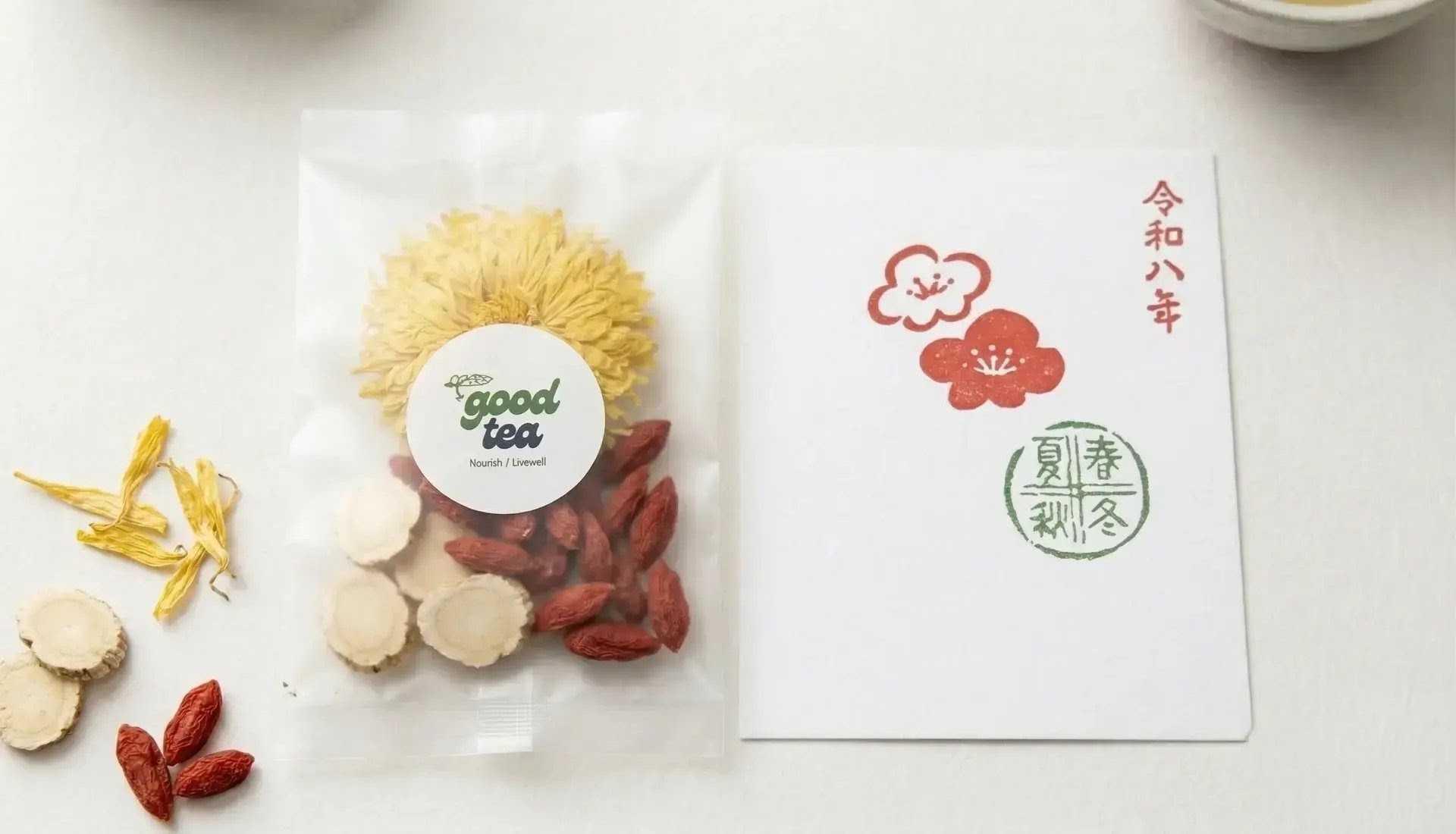 Good Tea Focus & Flow blend pouch with chrysanthemum, ginseng and goji, alongside a seasonal card and loose botanicals
